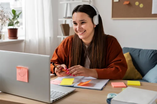 Mujer joven estudiando con portátil y auriculares, ejemplo de microlearning OffLesson